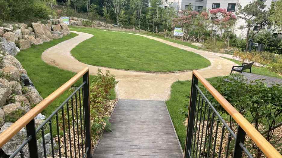 계단 아래 원형 잔디마당과 굽은 산책로